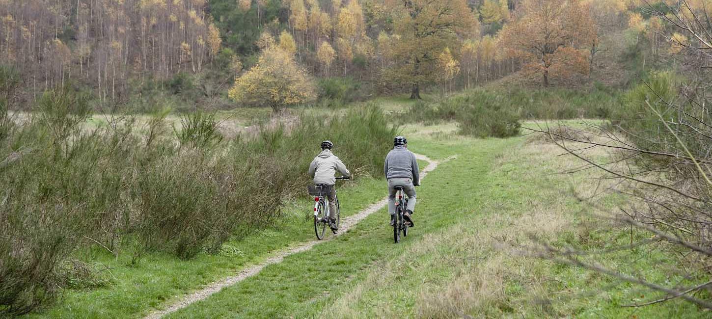 To cykellister cykler i bakkelandskab på Herregårdsruten